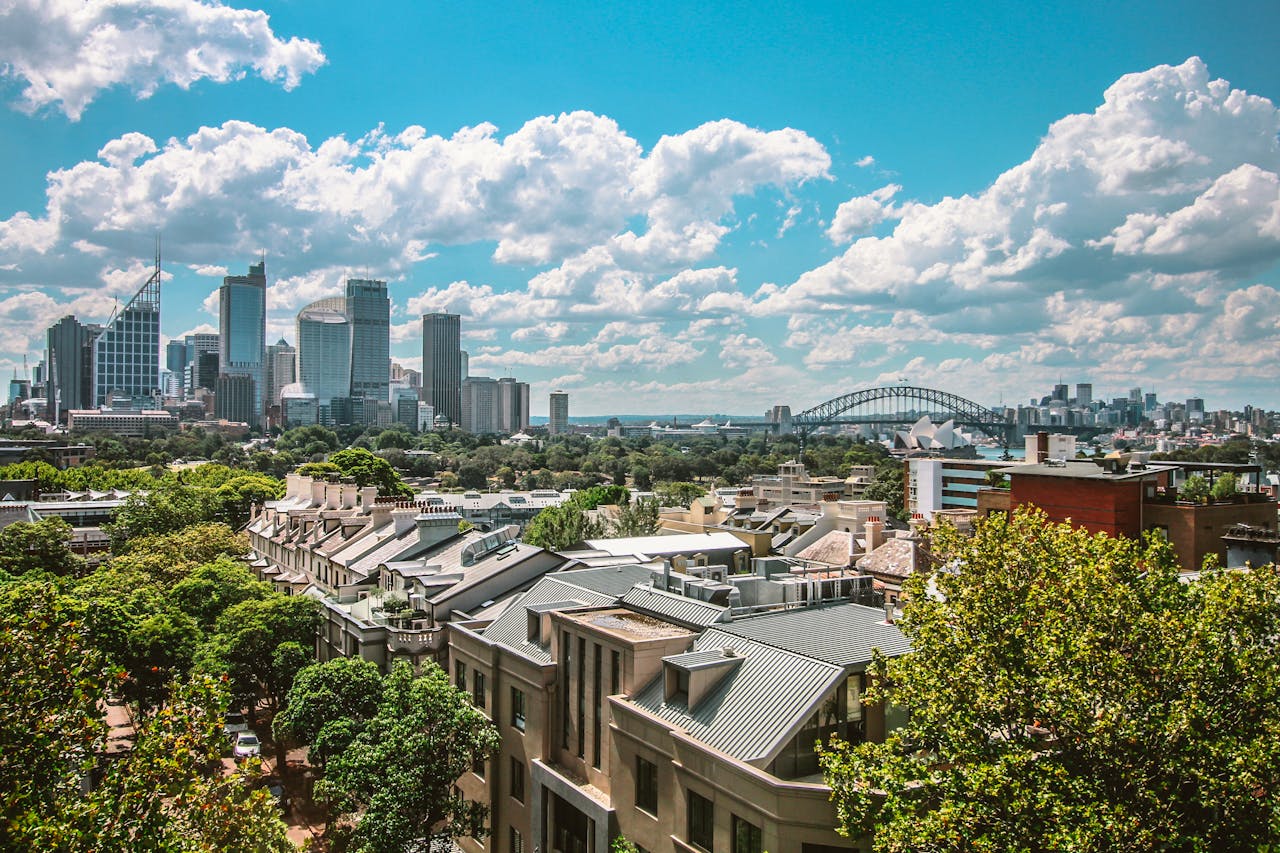 Stunning view of Sydneys skyline featuring the Harbour Bridge and Opera House under a clear blue sky.
